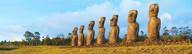 Moai statues of Ahu Akivi facing ocean at sunset